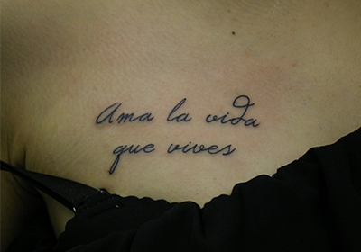 スペイン語「Ama la vida que vives」の文字のタトゥー