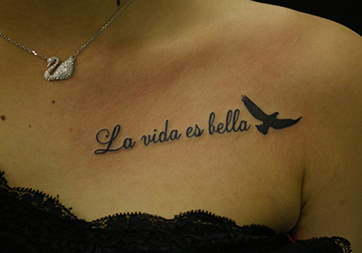 スペイン語「La vida es bella」の文字のタトゥー