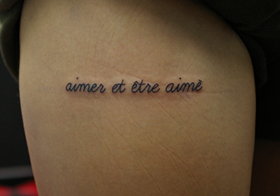 フランス語「aimer et être aimé」の文字のタトゥー
