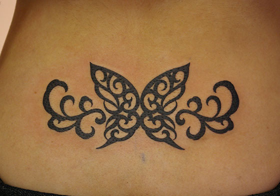 LUCKY ROUND TATTOOの女性の腰への蝶のトライバルタトゥー