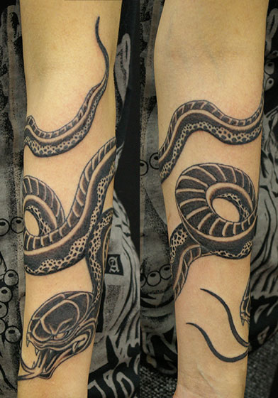 腕に巻いた蛇のタトゥー