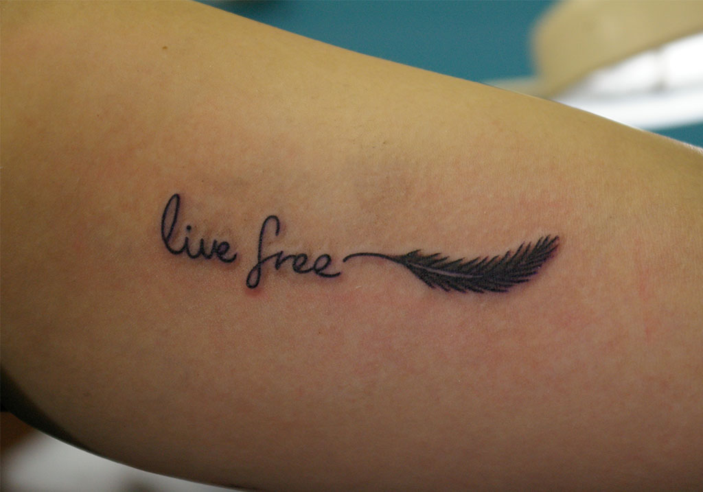 羽と「live free」の筆記体