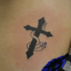 小さな十字架とヘビのタトゥー