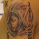 女性の横顔とオールドイングリッシュの文字のタトゥー