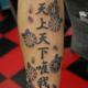 漢字「天上天下唯我独尊」と桜の花のタトゥー