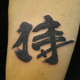 漢字「侍」と刀のタトゥー