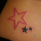 ピンク色と黒色の星のタトゥー