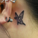 耳裏の小さな蝶のタトゥー