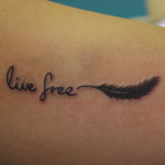 羽と「live free」の筆記体のタトゥー