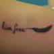羽と「live free」の筆記体のタトゥー