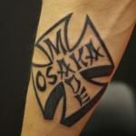 アイアンクロスと「OSAKA MADE」の文字のタトゥー