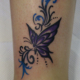紫色の蝶とトライバル飾りのタトゥー