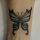 元の色をいかした蝶のカバーアップのタトゥー