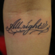 筆記体のレタリング「All right」のタトゥー