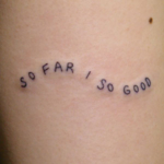 「SO FAR SO GOOD」の文字のタトゥー