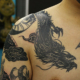 胸への龍のタッチアップのタトゥー