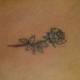 デコルテへのラインワークの薔薇のタトゥー